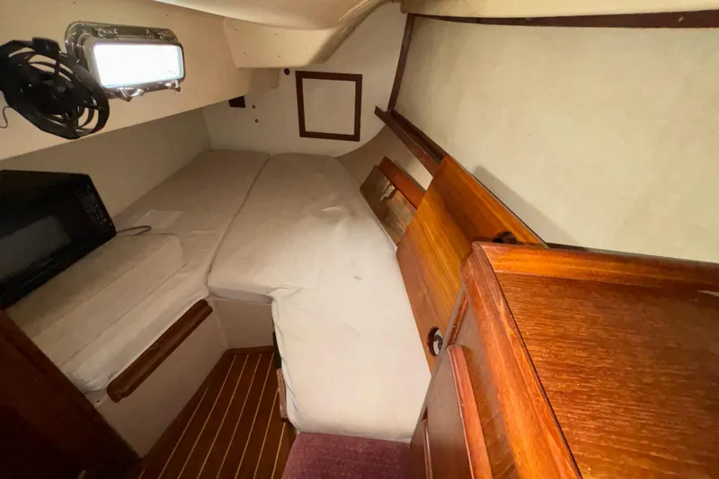 Slide: The Image of 1987 Island Packet 38 sailboat cabin with wooden interior and cozy sleeping area. - 28