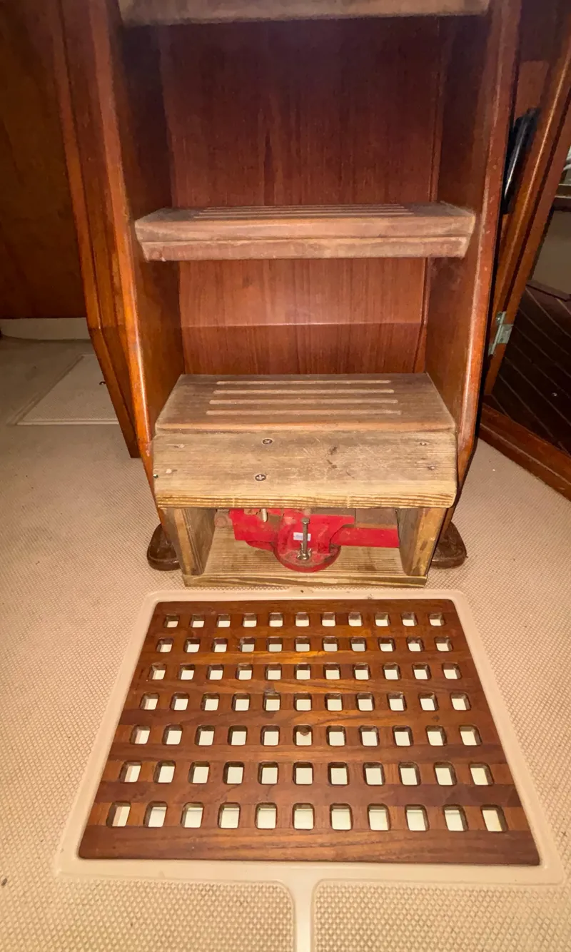 Slide: The Image of Wooden interior of 1987 Island Packet 38 sailboat with storage shelves and red valve. - 29