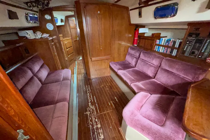Slide: The Image of Interior of 1987 Island Packet 38 sailboat with plush seating and wooden finishes. - 3