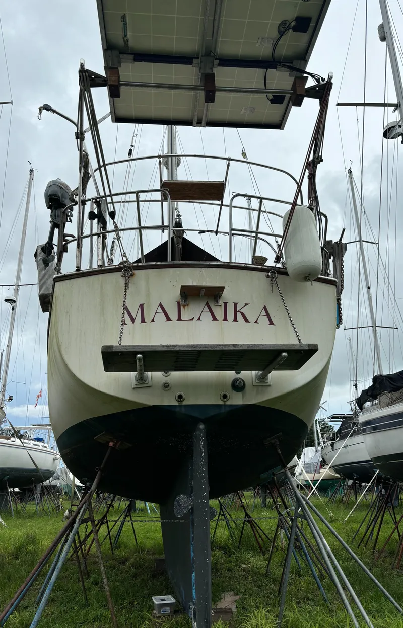 Slide: The Image of 1987 Island Packet 38 sailboat "MALAIKA" on stands, with solar panels, in a boatyard. - 33