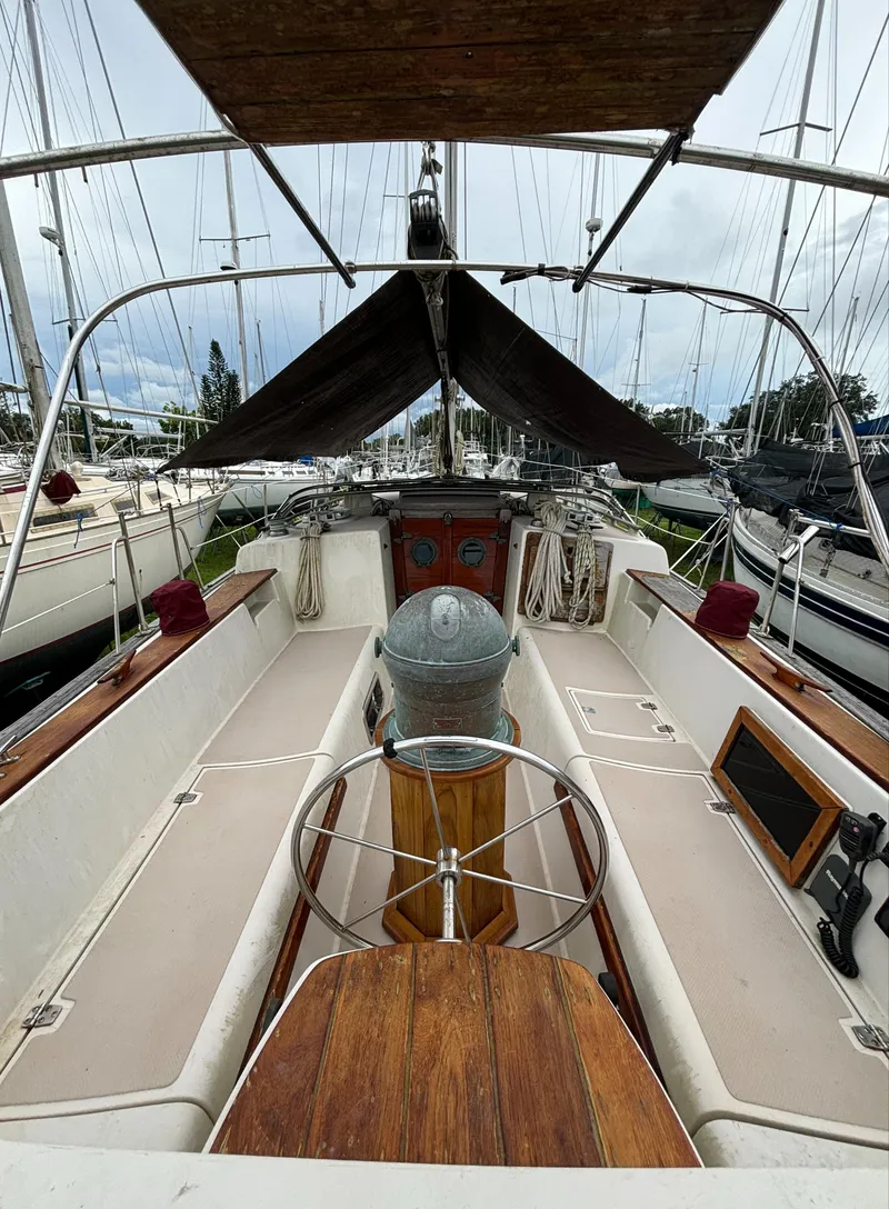 Slide: The Image of 1987 Island Packet 38 sailboat cockpit with wooden accents and steering wheel. - 35