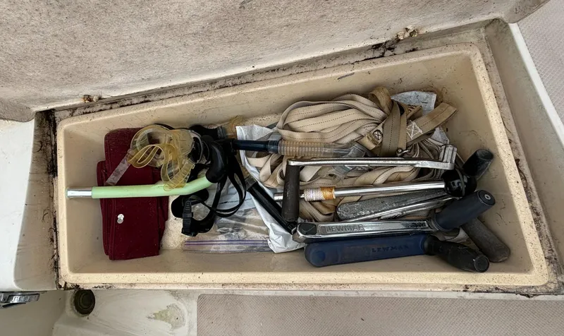 Slide: The Image of Tool compartment on 1987 Island Packet 38 sailboat, containing various tools and straps. - 37