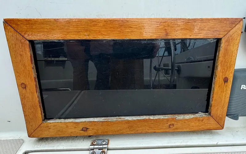 Slide: The Image of Wood-framed window on 1987 Island Packet 38 sailboat, reflecting interior details. - 39