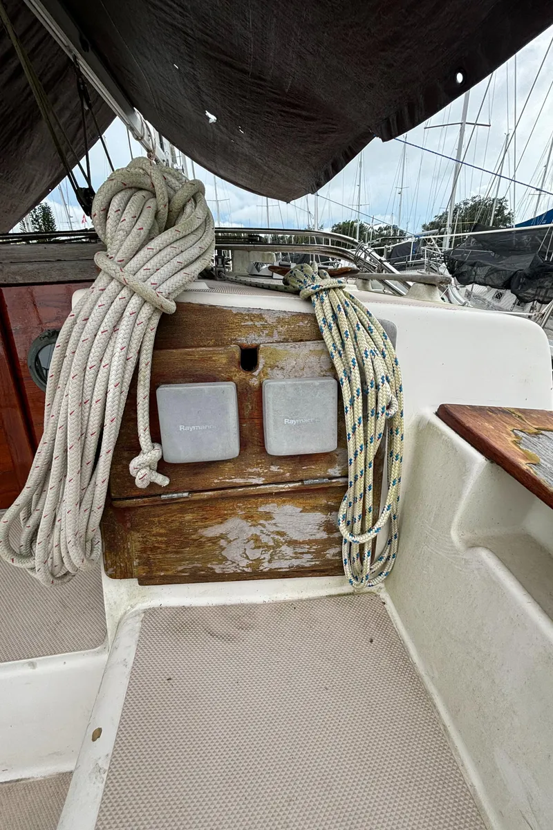 Slide: The Image of 1987 Island Packet 38 sailboat cockpit with ropes and wooden paneling. - 44