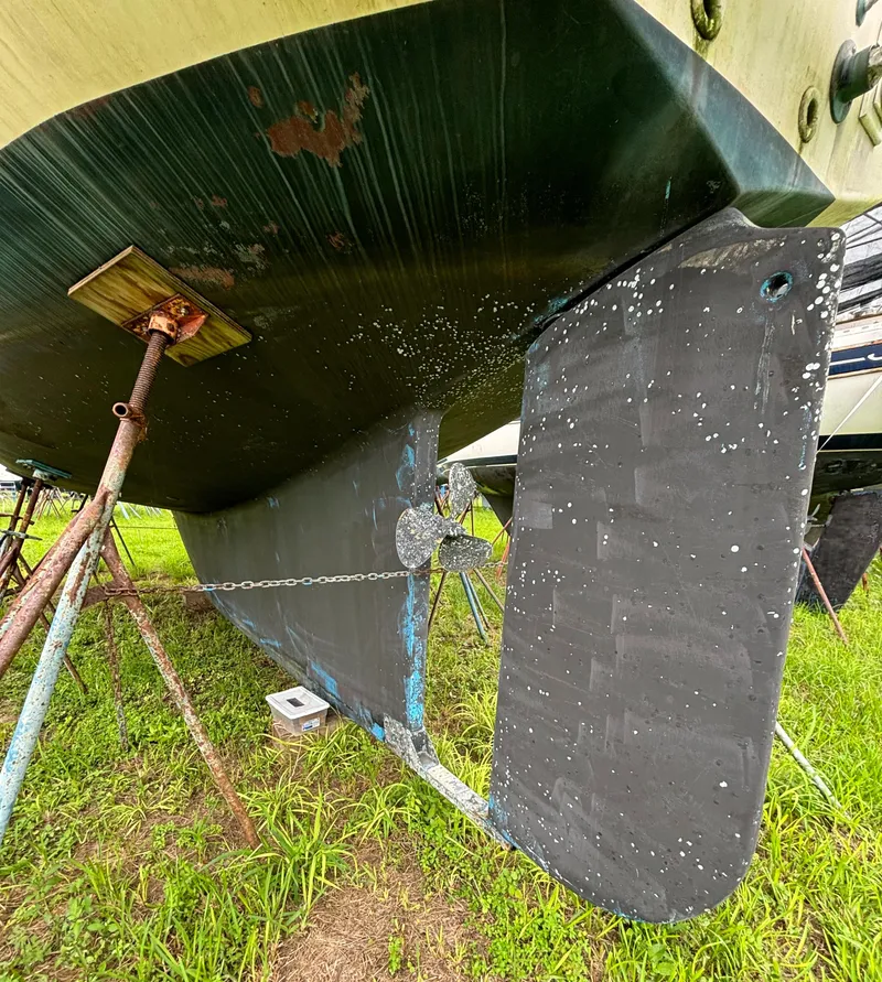 Slide: The Image of 1987 Island Packet 38 sailboat hull and rudder on stands, showing propeller and keel. - 45