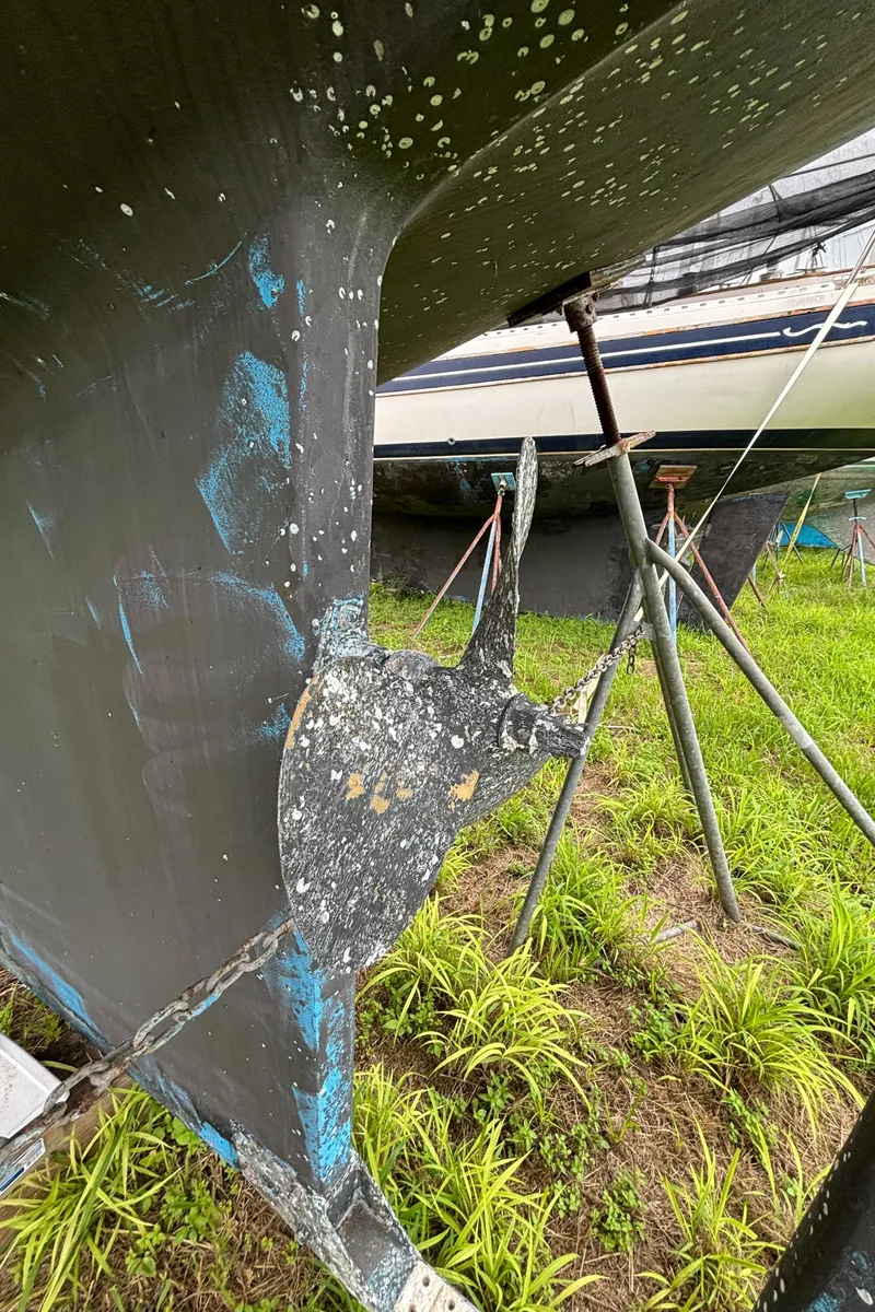 Slide: The Image of 1987 Island Packet 38 sailboat hull with visible wear and marine growth. - 46