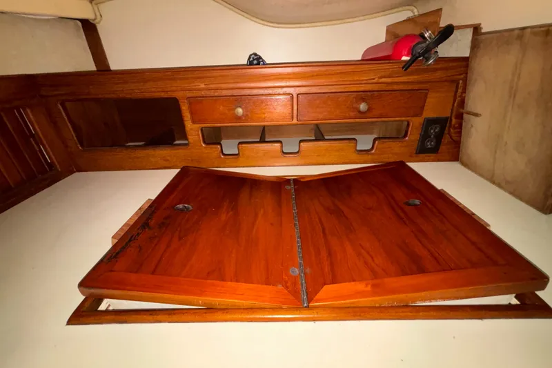 Slide: The Image of Interior of 1987 Island Packet 38 sailboat with wooden cabinetry and storage compartments. - 7