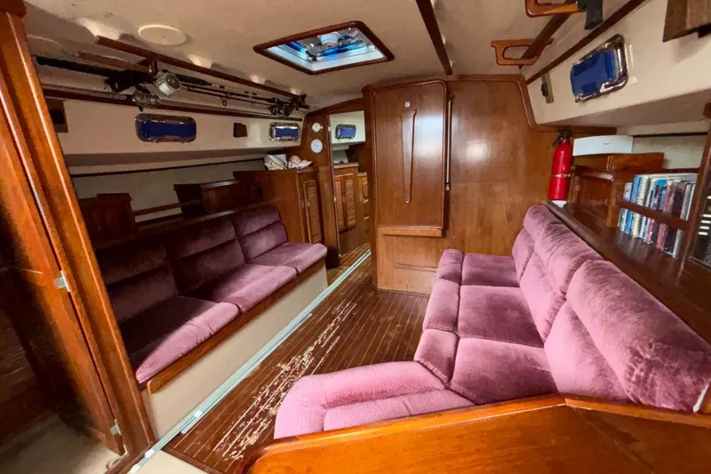 Slide: The Image of Interior of 1987 Island Packet 38 sailboat with plush seating and wooden finishes. - 9