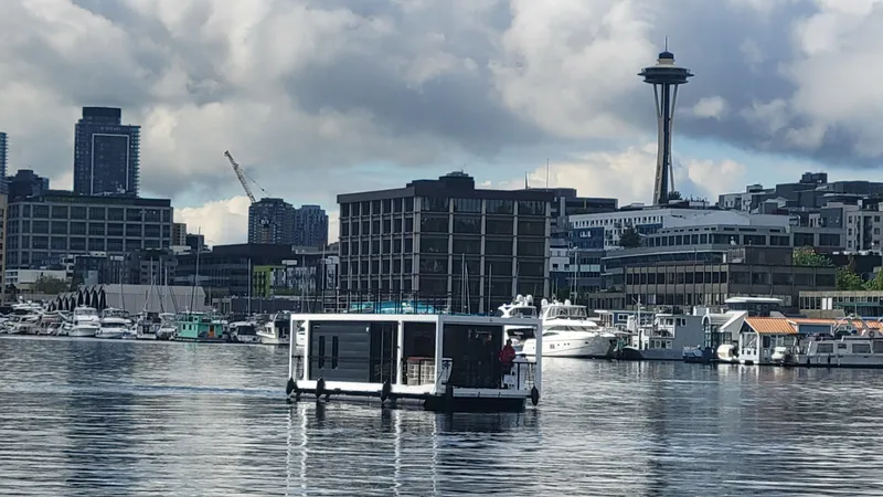 Slide: The Image of La Mare Modern 11 houseboat on Seattle waters with cityscape and Space Needle in background. - 42