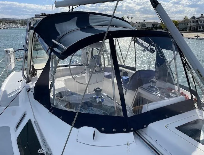 The Image of 2000 Hunter Passage 420 sailboat with blue canopy, docked in a sunny marina. - 0