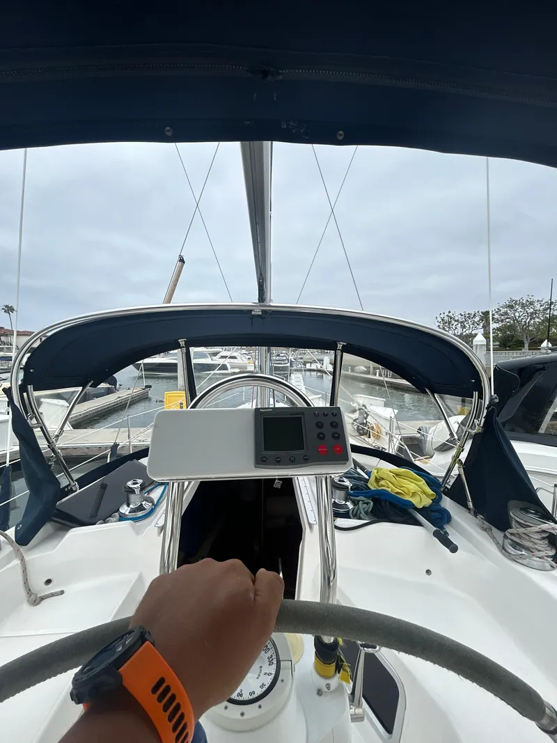 Slide: The Image of Person steering a 2000 Hunter Passage 420 sailboat in a marina. - 15