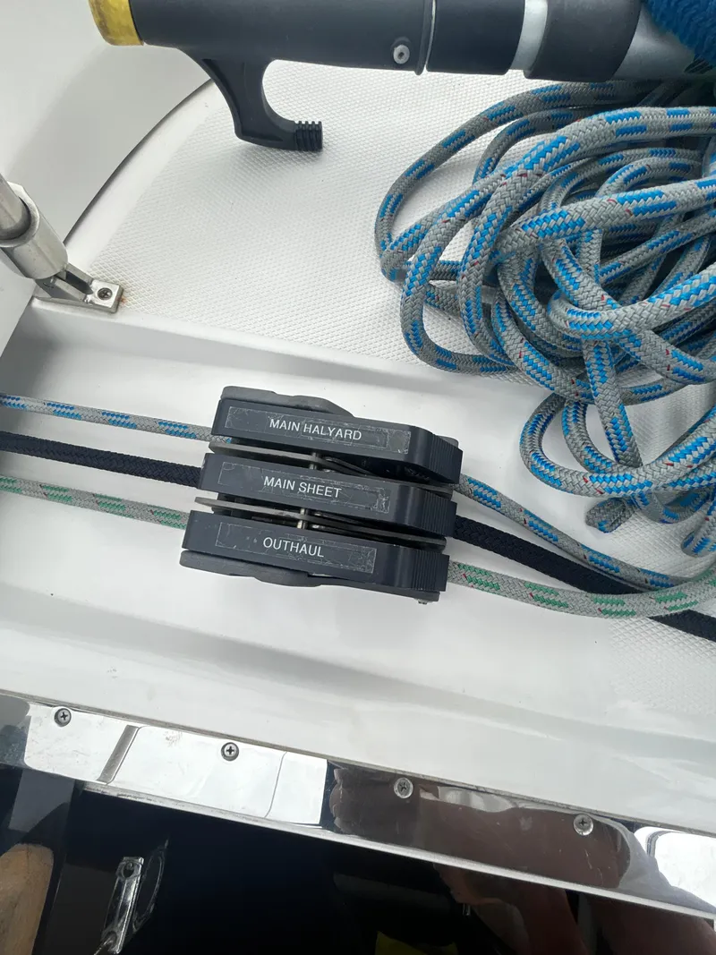 Slide: The Image of Sailboat rigging on a 2000 Hunter Passage 420, featuring ropes and labeled clutches. - 17