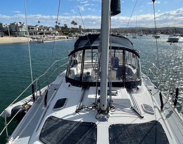 Slide: The Image of Sailboat Hunter Passage 420, 2000 model, docked in a scenic marina with waterfront homes. - 3