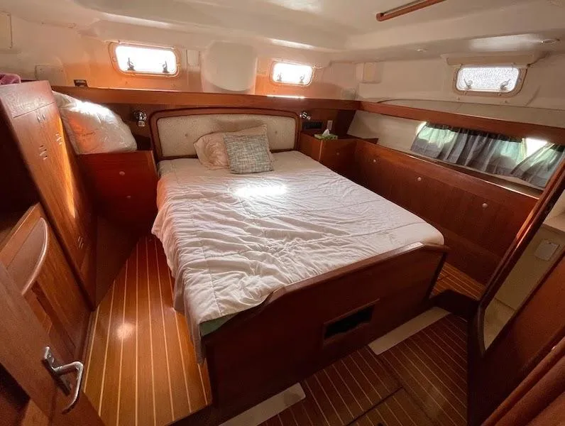 Slide: The Image of Cozy cabin interior of 2000 Hunter Passage 420 sailboat with wooden furnishings and bed. - 5