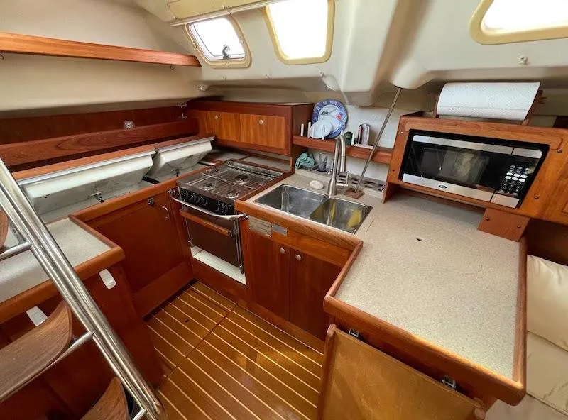 Slide: The Image of Interior of 2000 Hunter Passage 420 sailboat kitchen with wood cabinetry and appliances. - 6