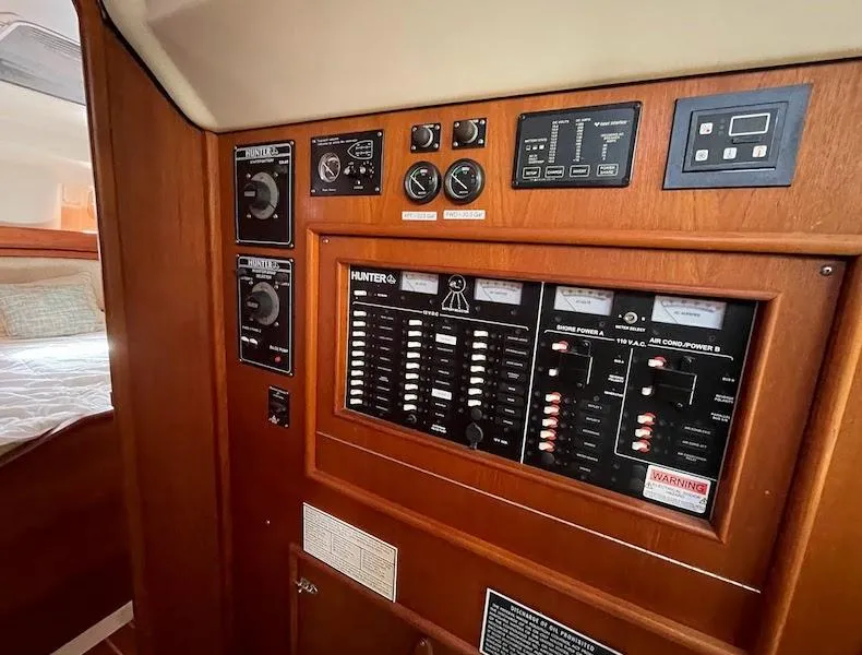 Slide: The Image of Control panel inside a 2000 Hunter Passage 420 yacht, featuring various switches and gauges. - 8