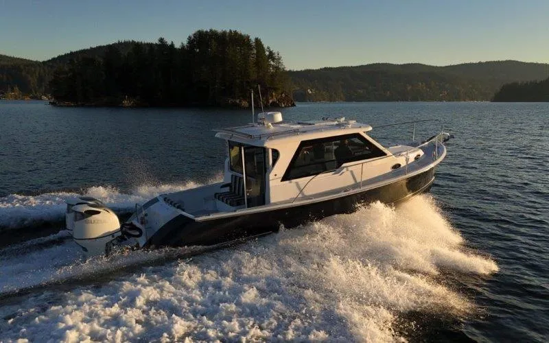 Slide: The Image of 2024 True North 34 boat cruising on a scenic lake at sunset. - 23