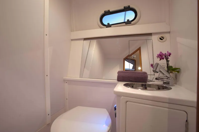 Slide: The Image of Modern bathroom in 2024 True North 34 boat with sink, mirror, and porthole window. - 7