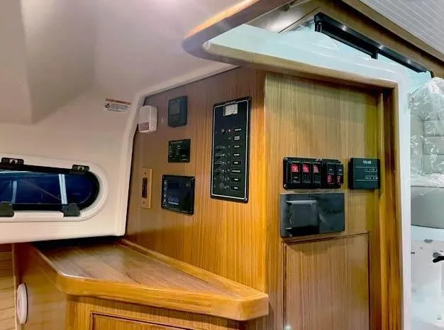Slide: The Image of 2024 True North 34 yacht interior with control panels and wood finish. - 8