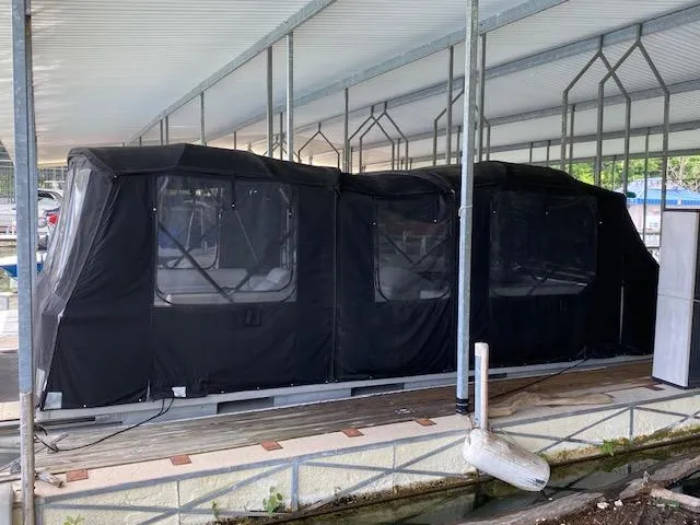 Slide: The Image of 1988 Sun Tracker PARTY BARGE covered in black tarp at dock. - 10