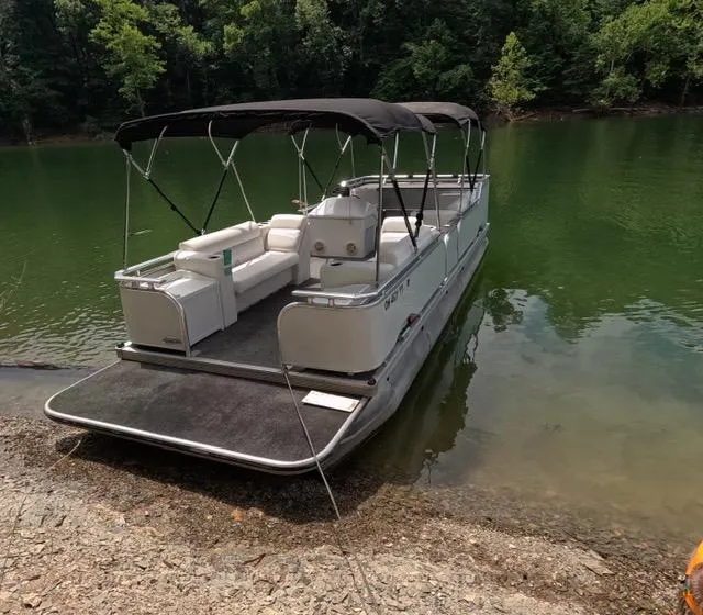 Slide: The Image of 1988 Sun Tracker PARTY BARGE pontoon boat docked on a serene lake. - 13
