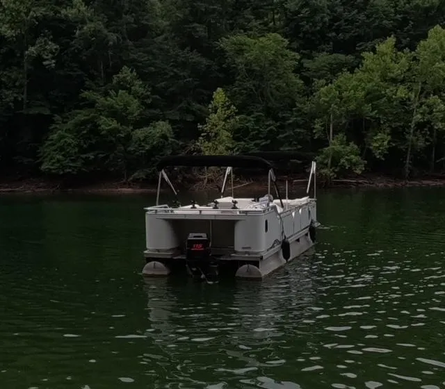 Slide: The Image of 1988 Sun Tracker PARTY BARGE pontoon boat on a serene lake. - 17