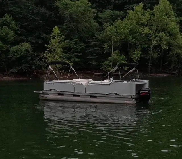 Slide: The Image of 1988 Sun Tracker PARTY BARGE pontoon boat on a serene lake. - 18