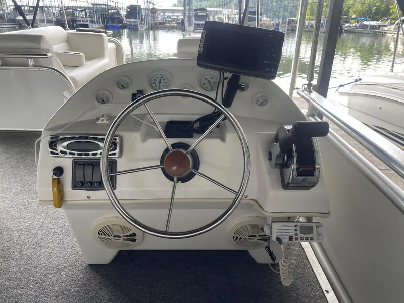 Slide: The Image of 1988 Sun Tracker PARTY BARGE helm with steering wheel, gauges, and control panel. - 19
