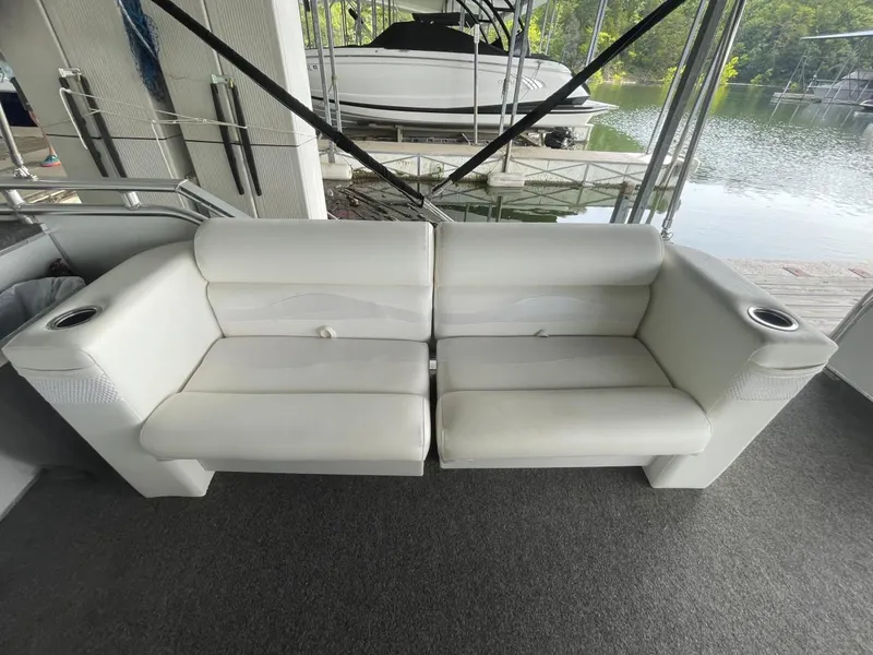 Slide: The Image of White seating on 1988 Sun Tracker PARTY BARGE, docked by a serene lake. - 25