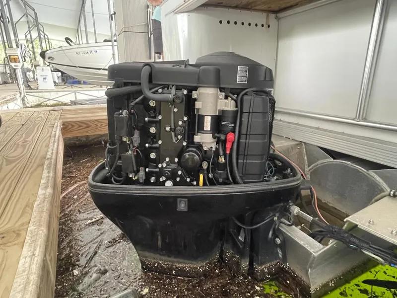 Slide: The Image of 1988 Sun Tracker PARTY BARGE outboard motor at dockside, partially submerged in water. - 34