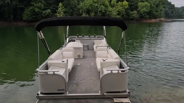 Slide: The Image of 1988 Sun Tracker PARTY BARGE pontoon boat on a serene lake with lush green trees. - 4