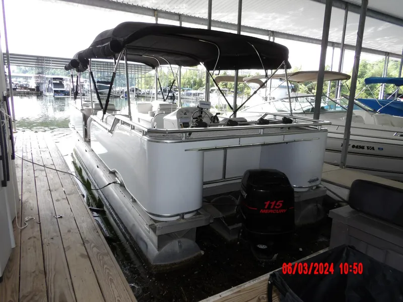 Slide: The Image of 1988 Sun Tracker PARTY BARGE pontoon boat docked under a covered marina. - 9