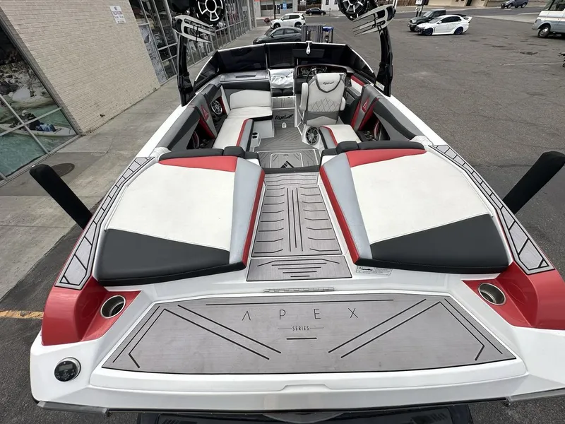 Slide: The Image of 2014 Tigé ASR boat interior with red and white seating, parked outdoors. - 13