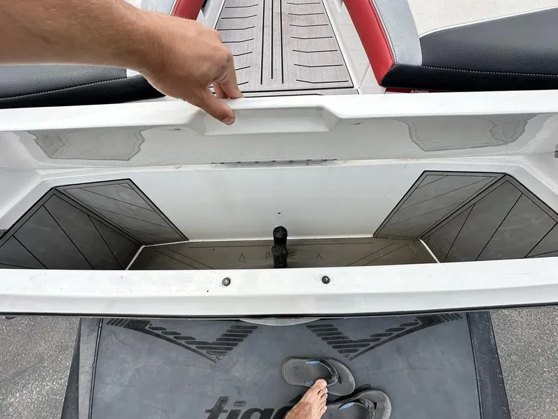 Slide: The Image of 2014 Tigé ASR boat storage compartment with open lid and visible flooring. - 14