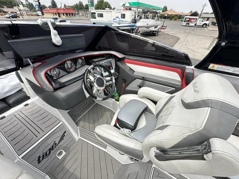 Slide: The Image of 2014 Tigé ASR boat interior with steering wheel, dashboard, and seating. - 18
