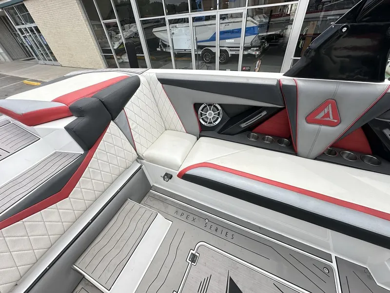Slide: The Image of 2014 Tigé ASR boat interior with red and gray upholstery, cup holders, and speaker system. - 21
