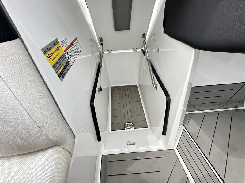 Slide: The Image of 2014 Tigé ASR boat interior showing storage compartment and capacity label. - 24