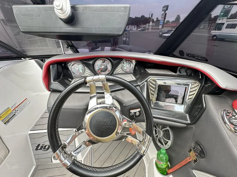 Slide: The Image of 2014 Tigé ASR boat dashboard with steering wheel, gauges, and touchscreen display. - 25