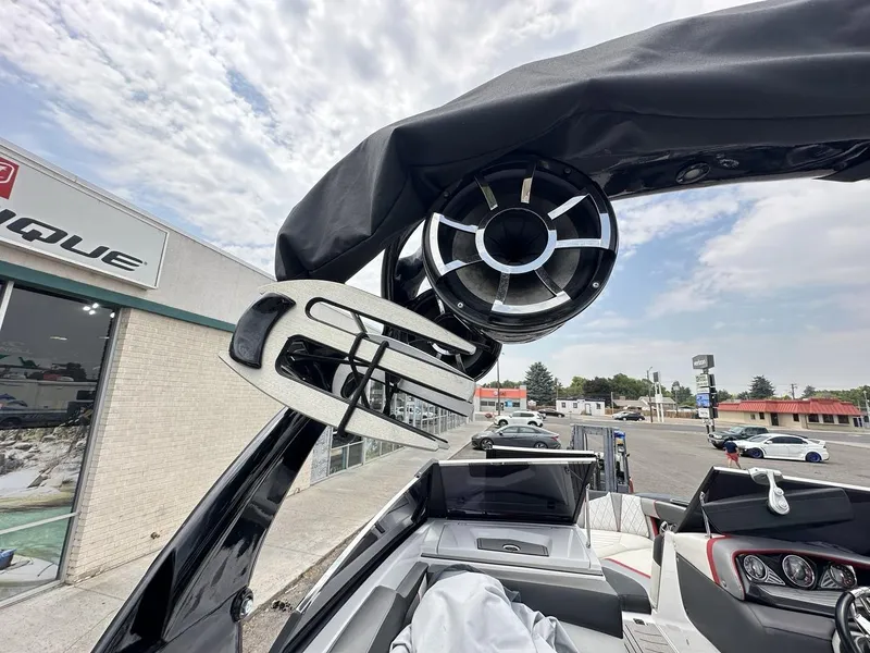 Slide: The Image of 2014 Tigé ASR boat with tower speakers and wakeboard rack, parked near a dealership. - 32