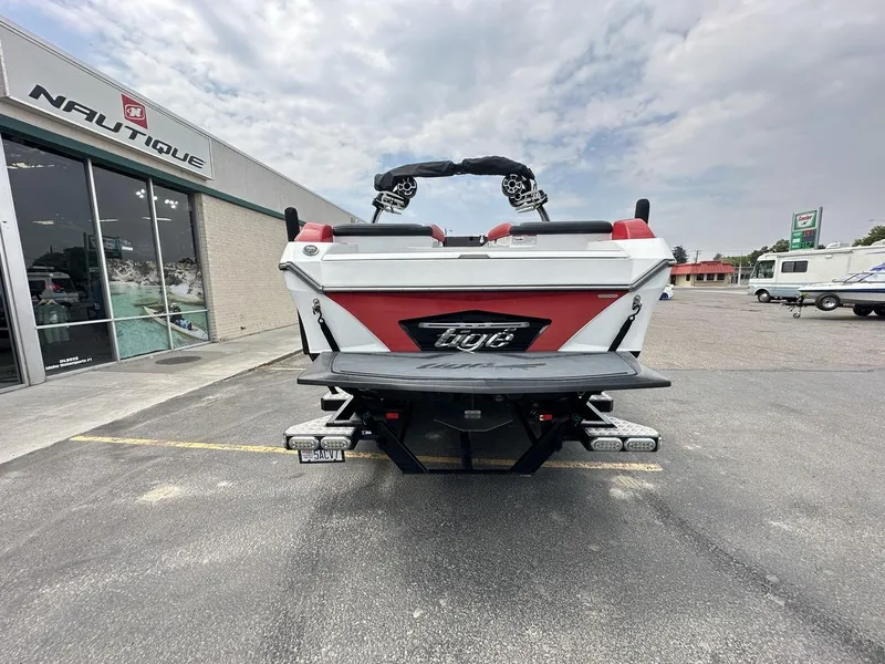 Slide: The Image of 2014 Tigé ASR boat parked outside Nautique dealership on a cloudy day. - 6