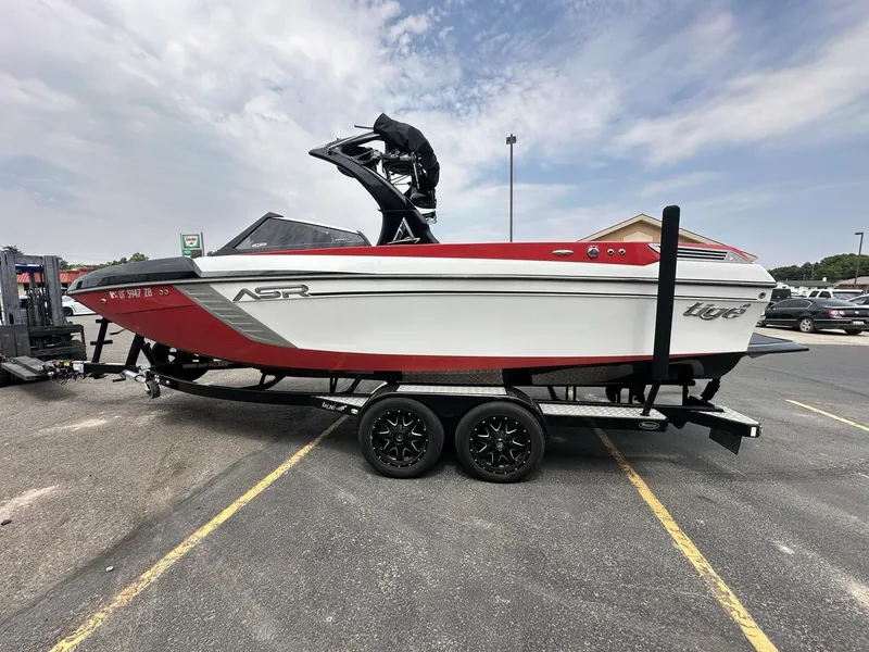 Slide: The Image of 2014 Tigé ASR boat on trailer, red and white design, parked in a lot. - 8