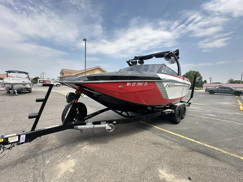 Slide: The Image of 2014 Tigé ASR boat on trailer in parking lot under cloudy sky. - 9