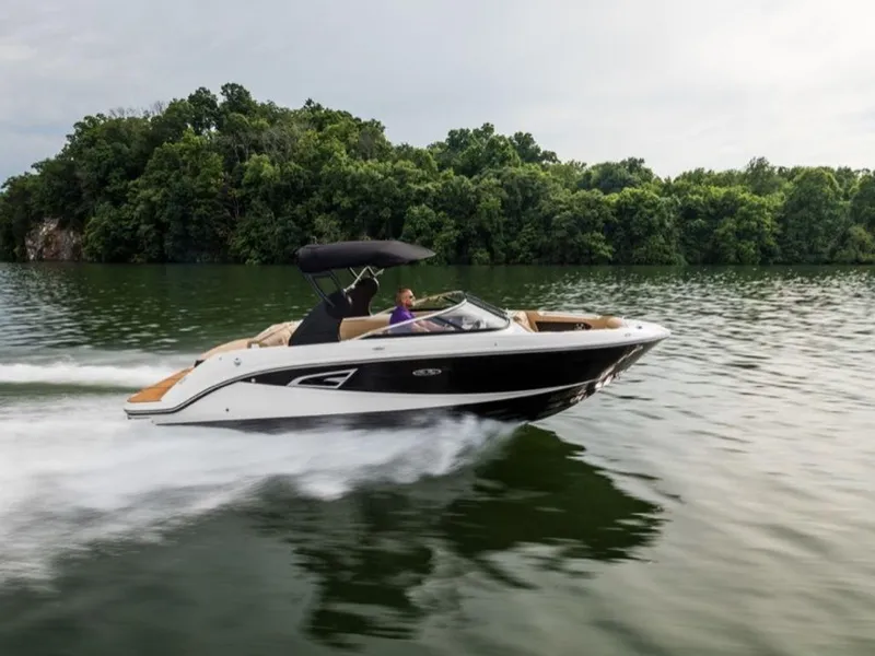 Slide: The Image of 2020 Sea Ray SLX 230 speedboat cruising on a lake with lush green trees. - 10