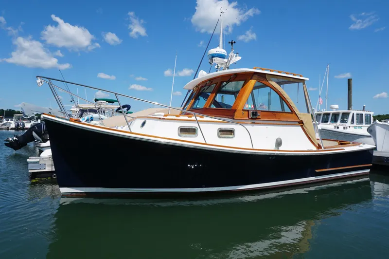 The Image of Webbers Cove 26 Pemaquid Beach boat, 2000 model, docked under a clear blue sky. - 1