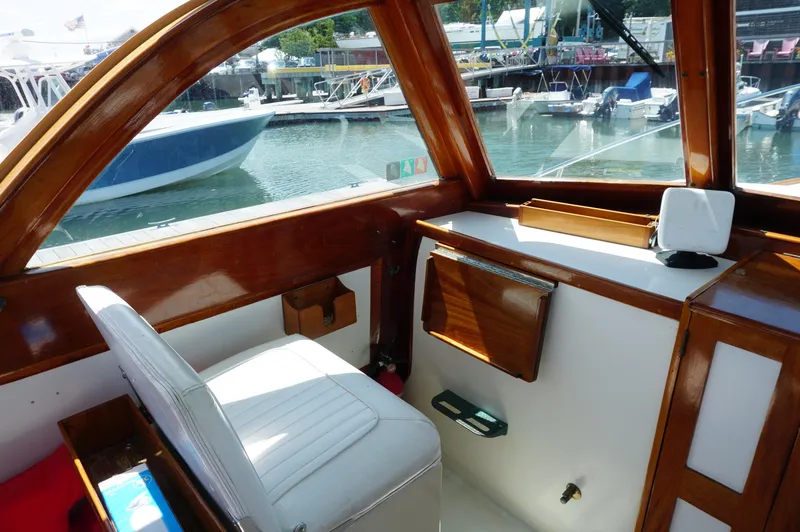 Slide: The Image of Interior of 2000 Webbers Cove 26 Pemaquid Beach boat, featuring wooden trim and white seating. - 10