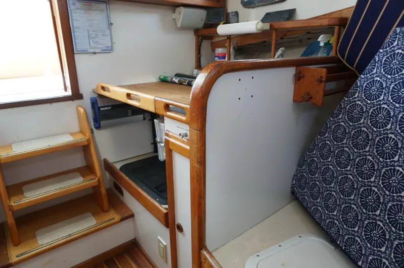 Slide: The Image of Interior of 2000 Webbers Cove 26 Pemaquid Beach boat with wooden stairs and compact storage. - 18