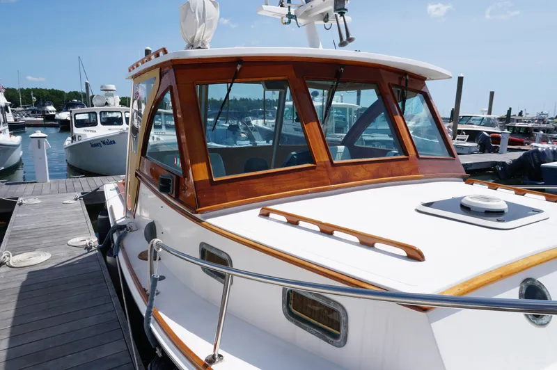 Slide: The Image of 2000 Webbers Cove 26 Pemaquid Beach boat docked at marina, featuring wooden cabin and sleek design. - 9