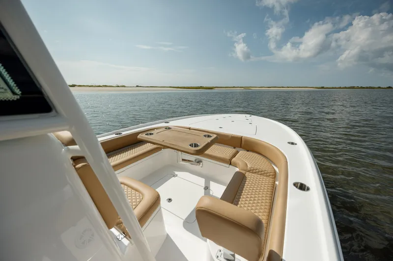 Slide: The Image of 2025 Caymas 26 HB boat interior with tan seating on calm water. - 19