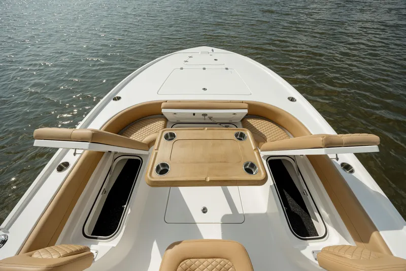 Slide: The Image of 2025 Caymas 26 HB boat deck with seating and storage on water. - 21