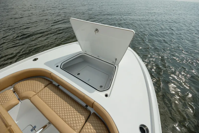 Slide: The Image of 2025 Caymas 26 HB boat with open storage compartment on calm water. - 25